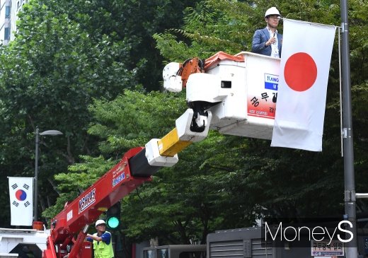 지난 2일 일본 정부가 한국의 화이트리스트 배제를 결정하자 서울 강남구 관계자들이 이에 대한 항의의 표시로 서울 테헤란로에 게양된 만국기 중 일장기를 철거하고 있다. /사진=장동규 기자