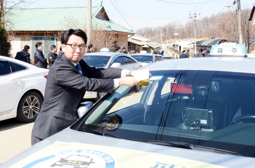 최종환 파주시장이 한 천원택시에 인증표를 부착하고 있다. /사진제공=파주시