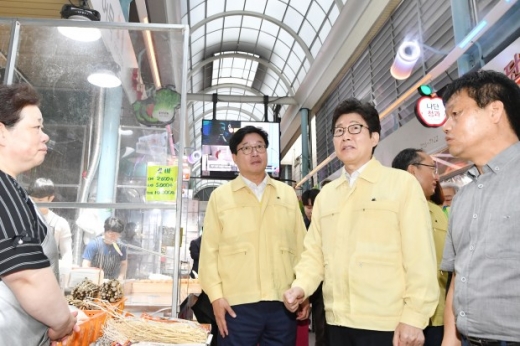 염태영 시장(왼쪽)과 조명래 장관이 구매탄시장에서 상인과 이야기를 나누고 있다. 사진 위쪽 색깔있는 관이 쿨링포그시스템이다. / 사진제공=수원시