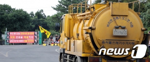 제주시 음식물류 쓰레기 수거차량이 19일 오전 봉개동쓰레기매립장주민대책위원회의 저지로 환경시설관리소에 들어가지 못해 관리소 앞에 정차해 있다.