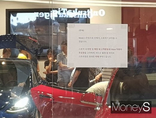 스타필드하남에 위치한 테슬라 전시장에 모델3 론칭으로 장내가 혼잡할 수 있다는 안내문이 부착된 모습. /사진=이지완 기자