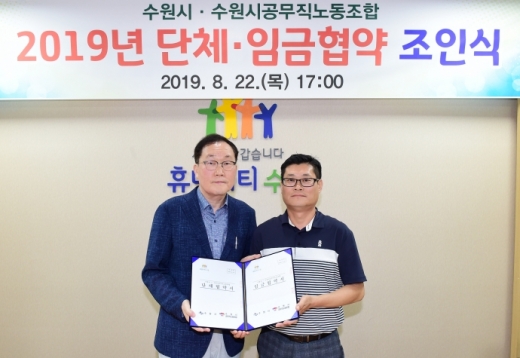 김경태 수원시 행정지원과장(왼쪽)과 김규동 수원시공무직노동조합 위원장(오른쪽)이 22일 시청 귀빈실에서 협약을 체결하고 기념촬영을 하고 있다. / 사진제공=수원시