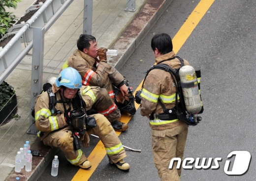 지난 15일 오전 서울 중구 남대문로에 위치한 남대문 오피스텔 화재현장에서 소방관들이 물을 마시고 있다. /사진=뉴스1