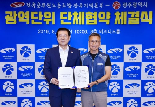 이용섭 광주광역시장이 30일 오전 시청 3층 비즈니스룸에서 열린 '광주광역시-전국공무원노동조합 광주지역본부 광역단위 단체협약 체결식'에 참석해 이종욱 전국공무원노동조합 광주지역본부장과 협약서에 서명을 한 뒤 기념촬영을 하고 있다./사진제공=광주광역시