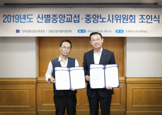 30일 서울 명동 은행회관에서 열린 ‘제5차 산별교섭회의’에서 김태영(왼쪽) 금융산업사용자협의회장(은행연합회장)과 허권 금융산업노동조합 위원장이 기념촬영을 하고 있다./사진제공=은행연합회