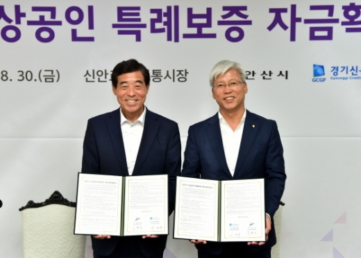 30일 윤화섭 안산시장(왼쪽)이 경기신용보증재단 관계자와 소상공인 특례보증 자금확대 협약식을 후 협약서를 들고 기념촬영을 하고 있다. / 사진제공=안산시