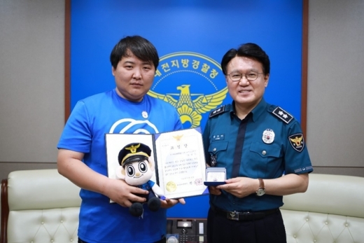 표창을 받은 이진우 바로고 대전 중앙 허브소속 라이더(왼쪽)가 황운하 대전지방경찰청장과 기념사진을 찍고 있다. /사진=바로고