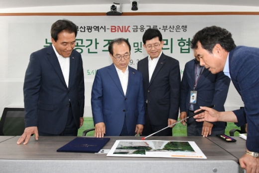 BNK부산은행은 3일 부산시청에서 부산시와 ‘녹색공간 조성 및 관리 추진 협약’을 체결했다.(왼쪽 첫번째부터 BNK금융그룹 김지완 회장, 부산광역시 오거돈 시장, 부산은행 빈대인 은행장)/사진제공=부산은행 