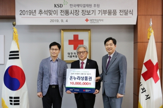 한국예탁결제원 이병래 사장(오른쪽 첫번째), 제해문 예탁결제원 노조위원장(왼쪽 첫번째)가 대한적십자사 서울특별시지사에 전통시장 장보기 후원금을 전달했다./사진제공=한국예탁결제원