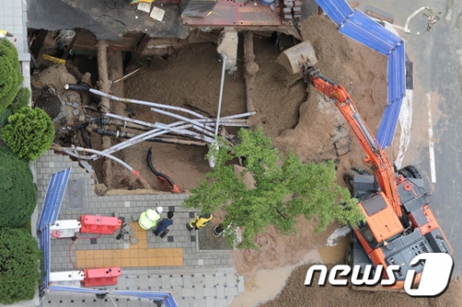 전국 대부분 지역에 많은 비가 내린 5일 오후 서울 영등포구 여의도의 한 거리에서 5m 크기의 싱크홀이 발생해 관계자들이 수습 작업을 하고 있다. /사진=뉴스1