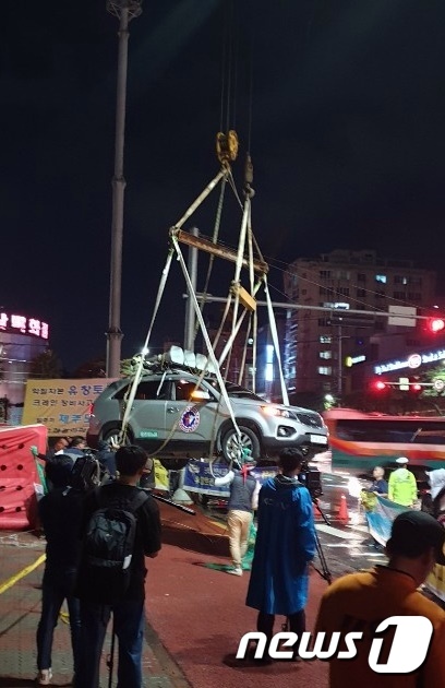 제주시 연동 신광사거리 앞에서 SUV차량에 타 크레인에 매달려 고공시위를 벌이던 노동자. /사진=뉴스1(제주소방안전본부 제공)    