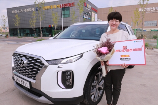 지난 6일 동아오츠카 울산지점에서 오로나민C 생기충전 구매인증 이벤트 1등 당첨자 김지은씨가 경품 팰리세이드 차량 앞에서 포즈를 취하고 있다. /사진=동아오츠카