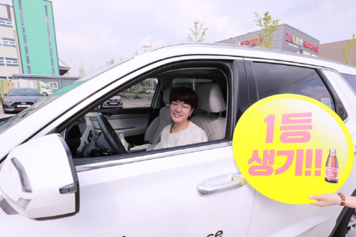 오로나민C 생기충전 구매인증 이벤트 1등 당첨자 김지은씨가 경품 팰리세이드에서 포즈를 취하고 있다. /사진=동아오츠카