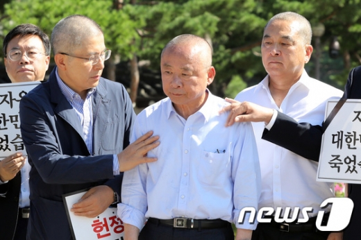 황교안 자유한국당 대표가 지난 18일 청와대 분수대 광장에서 삭발식을 가진 이주영 국회부의장(가운데)과 심재철 의원을 격려하고 있다. /사진=뉴스1