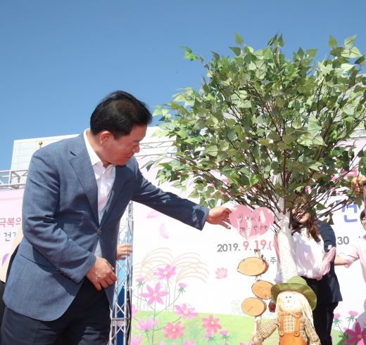 광명시는 9월19일 광명시민체육관에서 ‘2019 치매극복의 날 기념 행사’를 개최했다(박승원 광명시장이 '힘내세요' 희망메시지를 적어 나무에 매달았다). / 사진제공=광명시