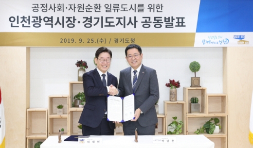 경기도청 상황실에서 이재명 지사와 박남춘 인천광역시장이 공정사회 · 자원순환 일류도시를 위한 인천광역시장-경기도지사 공동발표문에 서명을 한 후 기념촬영을 하고 있다. / 사진제공=경기도