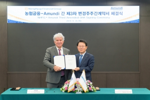 26일 서울 중구 소재 농협금융 본사에서 진행된 '농협금융-아문디(Amundi) 간 제3차 변경주주간계약서 체결식'에서 김광수 농협금융 회장(오른쪽)과 이브 페리에(Yves Perrier) 아문디 회장(왼쪽)이 계약서에 서명 후 기념촬영을 하고 있다./사진제공=농협금융