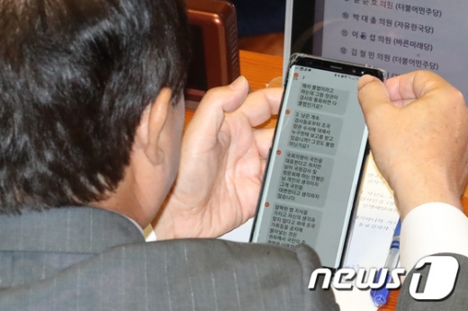 주광덕 자유한국당 의원이 지난 26일 국회에서 열린 정치분야 대정부질문 도중 자신에게 온 항의문자를 확인하고 있다. /사진=뉴스1
