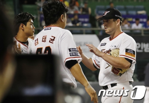 지난 7월9일 SK 와이번스 전에서 선발 투수로 등판한 채드 벨(오른쪽)이 8이닝 무실점 투구를 마친 뒤 마운드를 내려오며 동료들과 하이파이브를 하고 있다. /사진=뉴스1