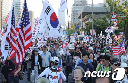 지난 3일 서울 광화문광장에서 열린 정부 규탄 집회에서 참가자들이 손에 깃발을 든 채 행진하고 있다. /사진=뉴스1