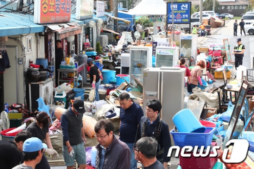4일 강원도 강릉시 경포동 진안상가 일대에서 제18호 태풍 ‘미탁’의 영향으로 침수피해를 입은 주민들이 가재도구를 밖으로 들어내고 복구 작업을 하고 있다. 2019.10.4/뉴스1 &copy; News1 고재교 기자