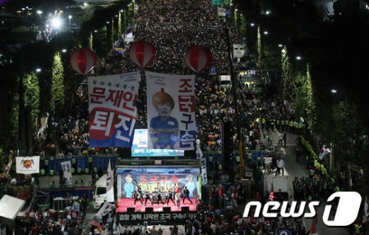 5일 오후 서울 서초구 대검찰청 앞 서초대로에서 제8차 사법적폐 청산을 위한 대규모 촛불문화제(사진 위)가 열린 가운데 보수단체 회원들이 경찰 저지선을 사이에 두고 맞불집회 형식의 '조국 구속 태극기집회'를 개최하고 있다. /사진=뉴스1