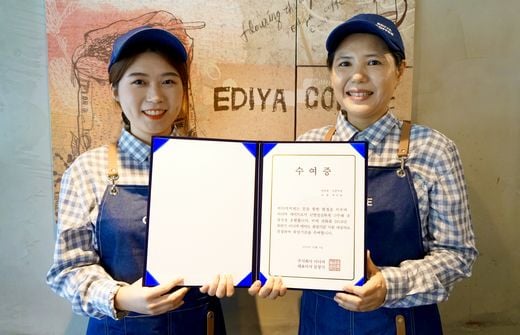 8일 이디야커피 등촌역점에서 이디야 메이트 곽수빈양(사진 왼쪽)이 이디야 메이트 희망기금을 전달받고 점주와 사진 촬영을 하고 있다. (사진제공=이디야커피)