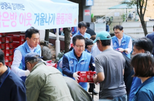 성대규 신한생명 사장(사진 중앙) 등 임원 봉사자들이 서울역 쪽방상담소 나눔터에서 쪽방촌 거주민들에게 라면박스를 전달하고 있다. 