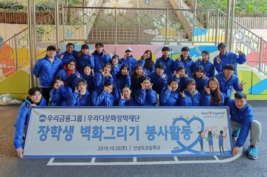 우리금융그룹 우리다문화장학재단 대학생 40여명이 서울 신상도초등학교에서 벽화그리기 봉사활동 후 사진촬영을 하고 있다./사진제공=우리금융