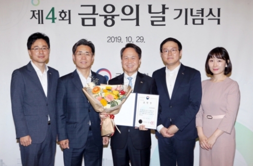 진옥동(가운데) 신한은행장이 29일 서울 영등포구 여의도 63컨벤션 센터에서 열린 ‘제4회 금융의 날 기념식’에서 수상한 직원들과 함께 기념촬영을 하고 있다./사진=신한은행