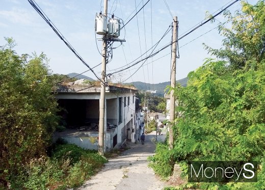 마을 안 낡은 폐건물과 그 뒤로 보이는 국정원. /사진=김노향 기자