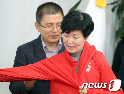 황교안 자유한국당 대표(왼쪽)가 31일 국회에서 열린 한국당의 '1호 인재' 영입 행사에서 이진숙 전 대전MBC 사장에게 당 점퍼를 입혀주고 있다. /사진=뉴스1