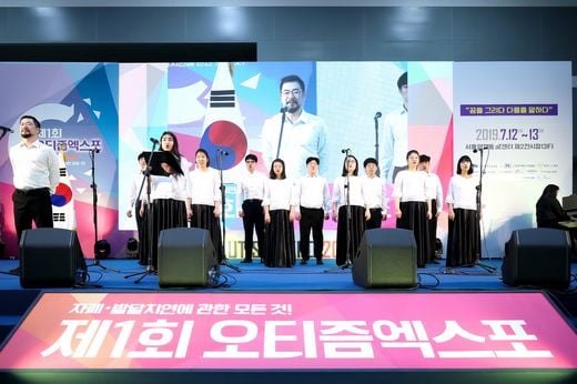 / 지난달 31일(목), ‘뉴딘파스텔’이 일자리제공형 분야의 ‘서울시 예비사회적기업’으로 선정됐다. 사진은 올해 7월 열린 제1회 오티즘엑스포 개막식에 참석해 초청공연을 선보이고 있는 골프존파스텔합창단. (사진제공=뉴딘파스텔)