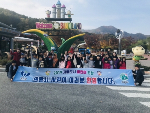 7일 자매도시인 전북 무주군을 방문한 의왕시 초등학생들이 반디랜드를 견학하는 가운데 관계자들과 기념촬영을 하고 있다. / 사진제공=의왕시