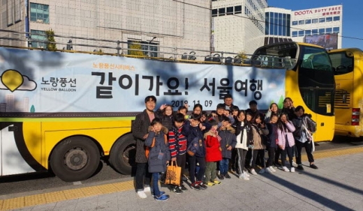 서울 동대문구 DDP 인근의 노랑풍선시티버스 앞에서 기념촬영 중인 ‘같이가요! 서울여행’ 참가자들. /사진제공=노랑풍선