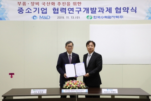 한수원(사장 정재훈, 왼쪽)은 13일 경기도 수원 소재 중소기업인 ㈜엠앤디(대표이사 이명진, 오른쪽)와 방화댐퍼 작동 시험장비 국산화 개발을 위한 협약을 체결했다./사진제공=한수원