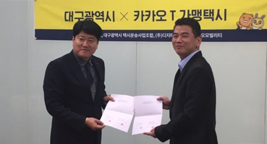 안규진 카카오모빌리티 사업부문 전무(오른쪽)가 자회사 KM솔루션을 대표해 김준홍 DGT모빌리티 대표와 업무협약을 맺고 기념사진을 찍고 있다. /사진=카카오모빌리티