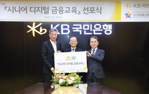 허인(왼쪽) KB국민은행장이 27일 서울 여의도본점에서 열린 ‘시니어 디지털 금융교육’ 선포식에서 윤덕홍 시니어금융교육협의회장 및 전용만 한국노인종합복지관협회장과 기념촬영을 하고 있다./사진=KB국민은행