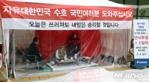  김성태 자유한국당 의원이 1일 오전 청와대 분수대 앞에서 황교안 대표에 이어서 4일째 단식중인 신보라 최고위원의 어깨를 주물러주고 있다. 왼쪽은 함께 단식중인 정미경 최고위원./사진=뉴시스