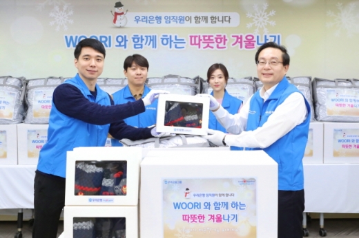 손태승(맨 오른쪽) 우리금융그룹 회장이 11월 25일 임직원들과 함께 아동복지기관으로 전달될 겨울용품 포장을 한 뒤 기념촬영을 하고 있다./사진=우리금융