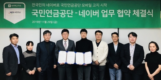 유봉석 네이버 서비스운영총괄(중앙 오른쪽)과 김대순 국민연금공단 정보화본부 본부장(중앙 왼쪽)이 업무협약서를 교환하고 있다. /사진=네이버