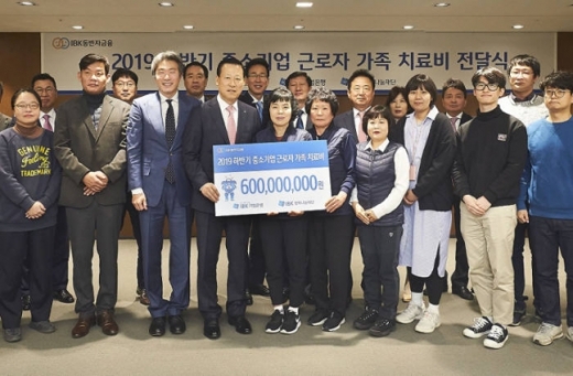 9일 을지로 기업은행 본점에서 김도진 행장(앞줄 왼쪽 네 번째)과 중소기업 근로자 가족들이 치료비 전달식을 마치고 기념촬영했다./사진=기업은행