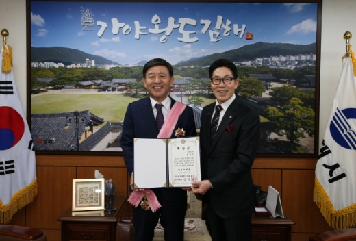11일 재향군인회 중앙회장을 대신해 손도수 경남‧울산재향군인회장이 허성곤 김해시장(왼쪽)에게 행군대취장을 전달했다./사진제공=김해시