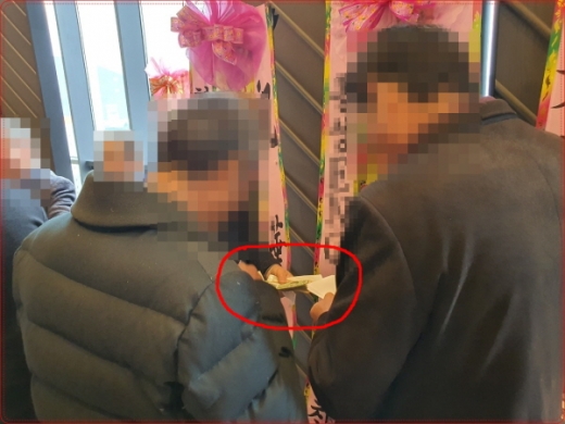지난 21일 오후2시 경남 창원의 A웨딩컨벤션 힐그랜드홀에서 조근제 함안군수의 큰딸 결혼식에 축하차 참석한 하객들이 5만원권 돈다발을 손에 쥔채 축의금 봉투를 만들고 있다. &copy;머니S 독자 제공.