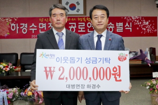 경남 합천군 하경수 대병면장이 지난 24일 대병면사무소에서 열린 퇴임식에서 불우이웃성금 200만원을 기탁하고 문준희 군수(사진 오른쪽)와 함께 기념촬영을 하고 있다. &copy;합천군 제공.