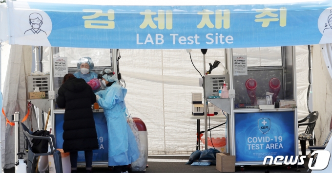 지난 25일 오전 제주국제공항 워킹 스루 진료소(개방형 선별진료소)에서 해외 입국자가 검체검사를 받고 있다. /사진=뉴스1